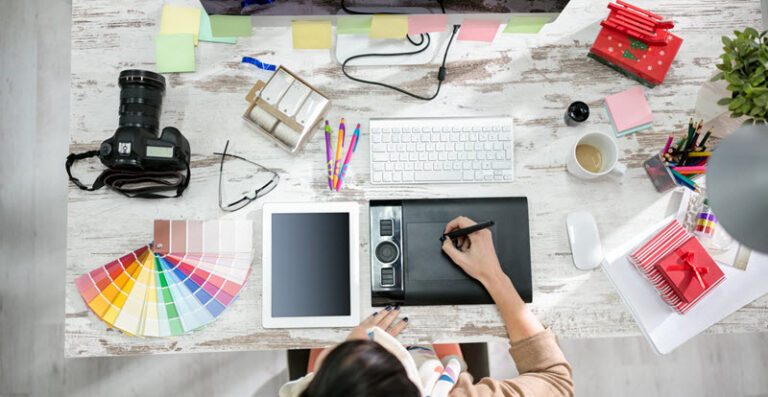 woman sitting at her desk designing a logo