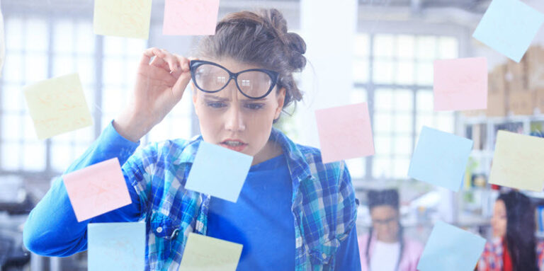 woman looking confused while reading sticky note