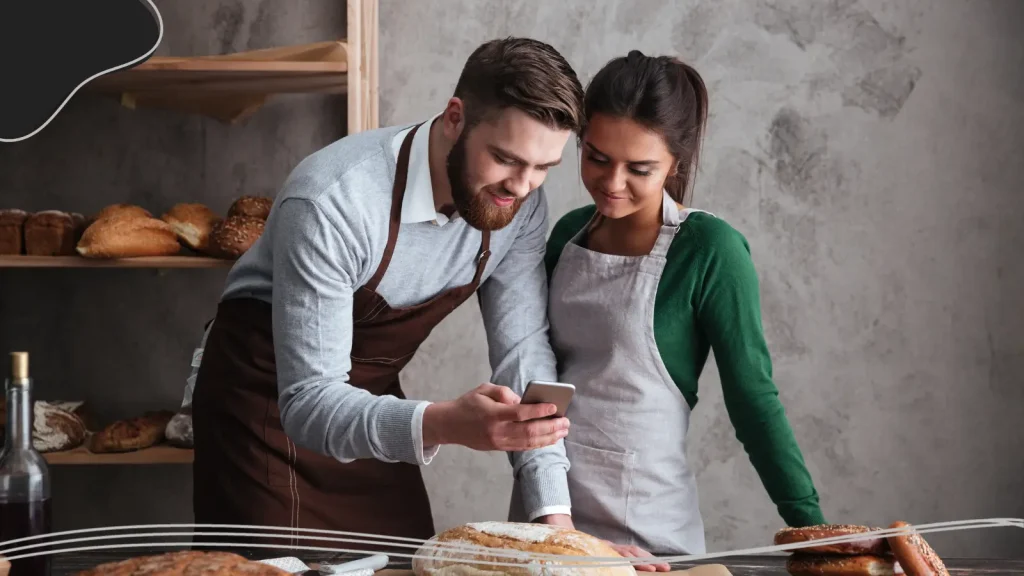 Two people taking a photo in their bakery business