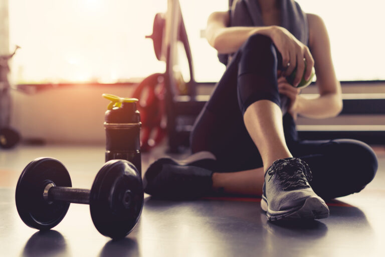 woman on floor exercising with dumbbell