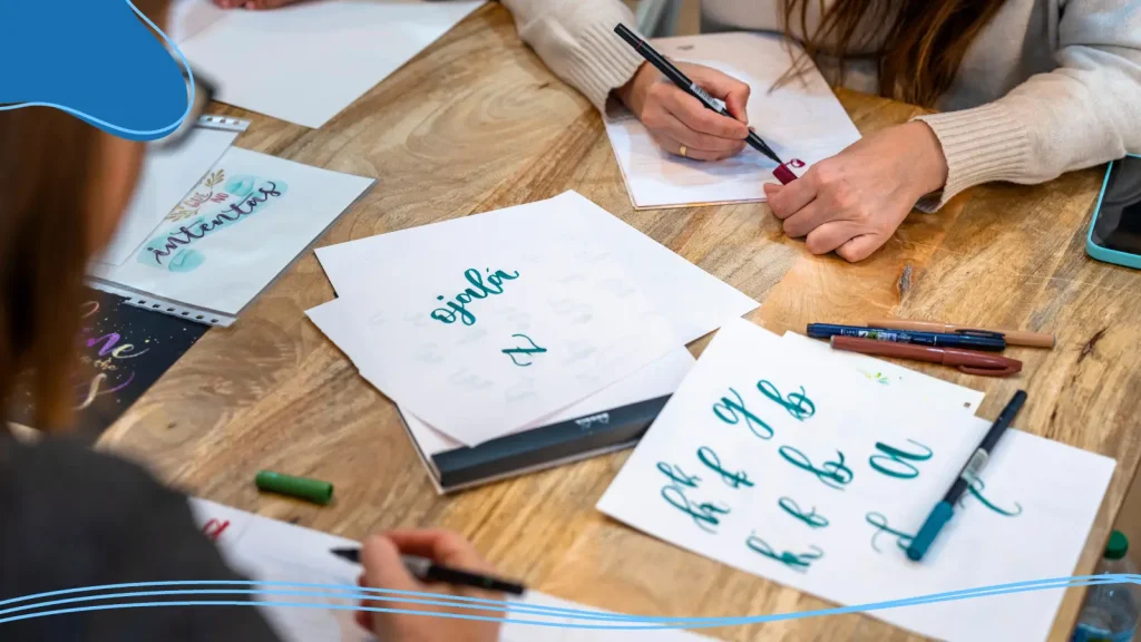 People drawing cursive letters on paper