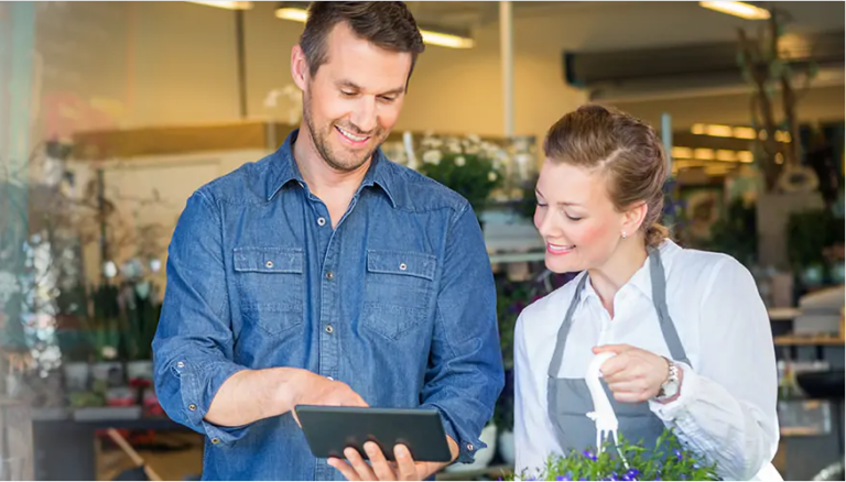 Male and female Entrepeneur searching for research about small business loans on their tablet