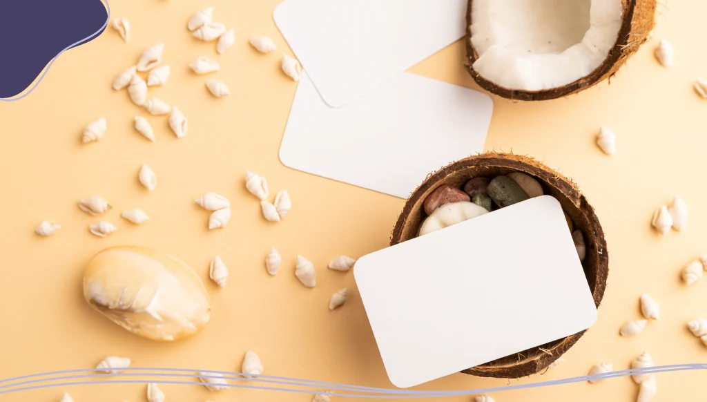 White paper business card with coconut and seashells on orange pastel background