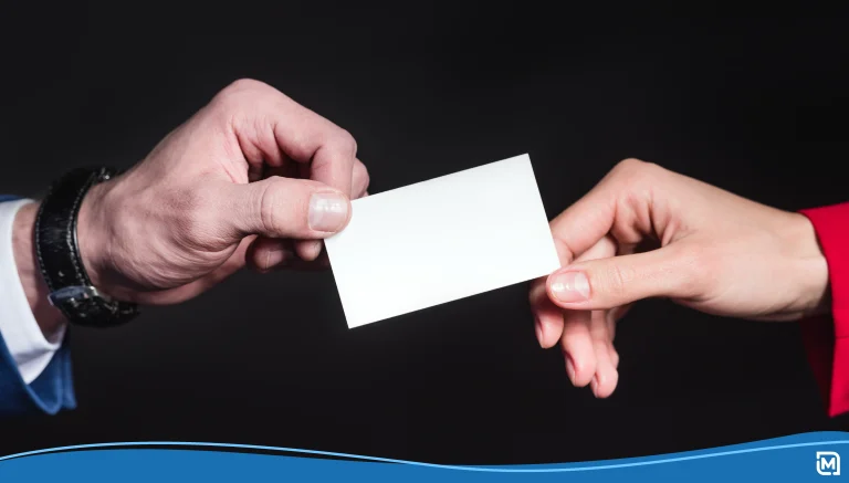 Close-up partial view of male and female hands holding blank card isolated on black