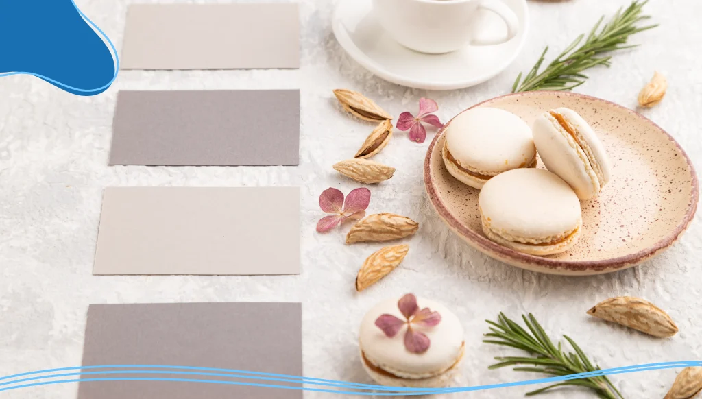 Gray business card mockup with cup of coffee, almonds ,and macaroons on gray concrete