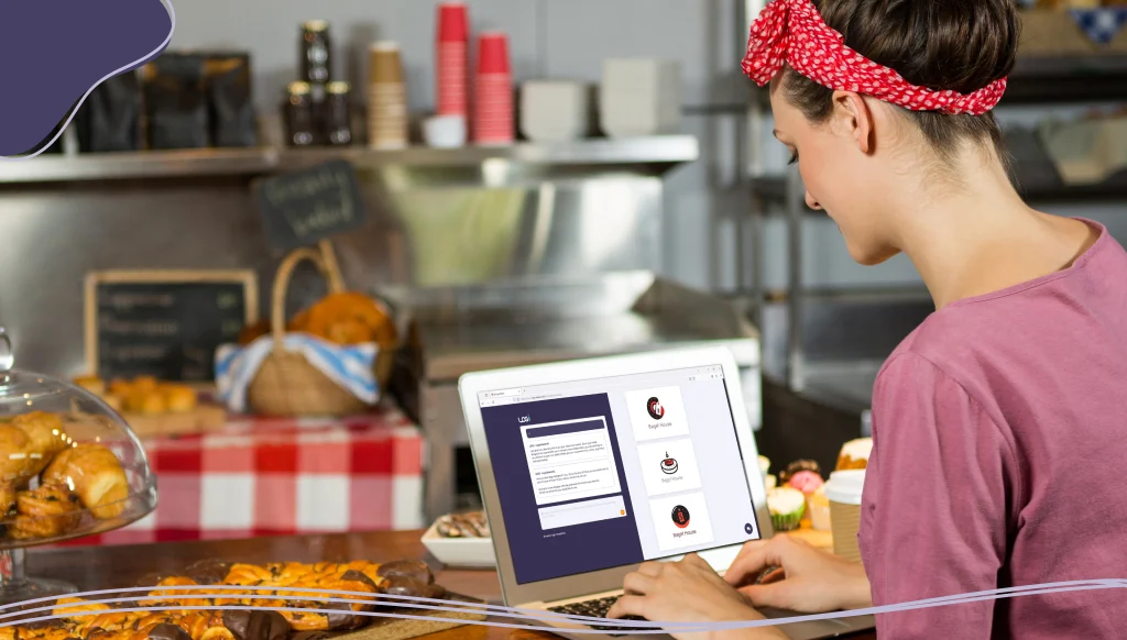 Woman using laptop at bakery counter
