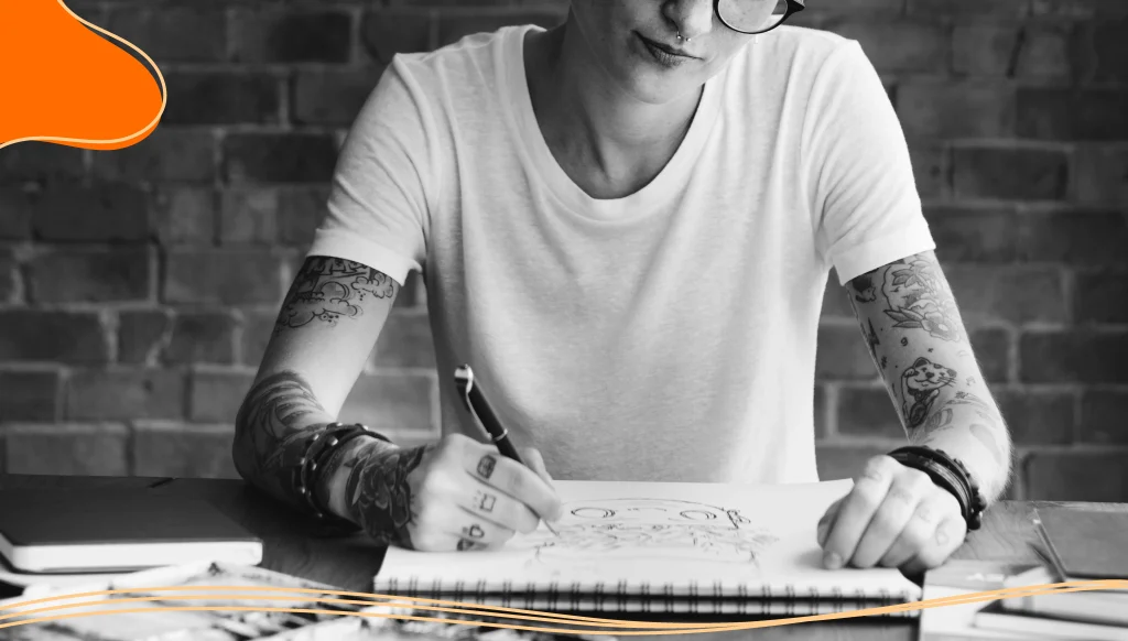 Black and white photo of a woman drawing a cartoon logo