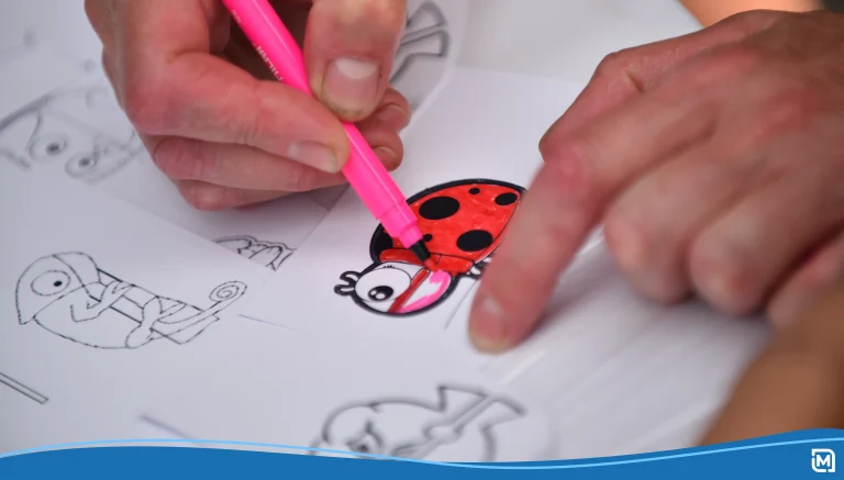 Child draws with a felt-tip pen on white paper