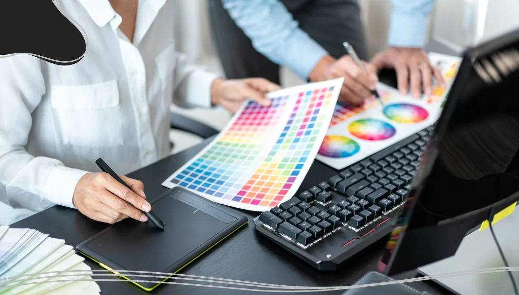 Two creative graphic designer team working on color selection and drawing on graphic tablet