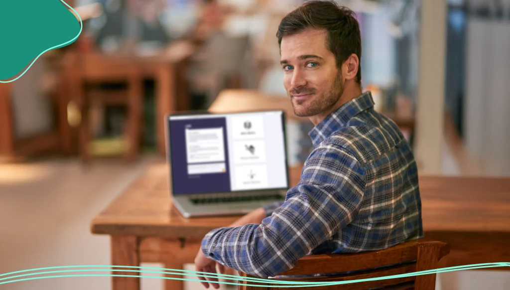 Portrait of a young man using his laptop while sitting in a coffee shop