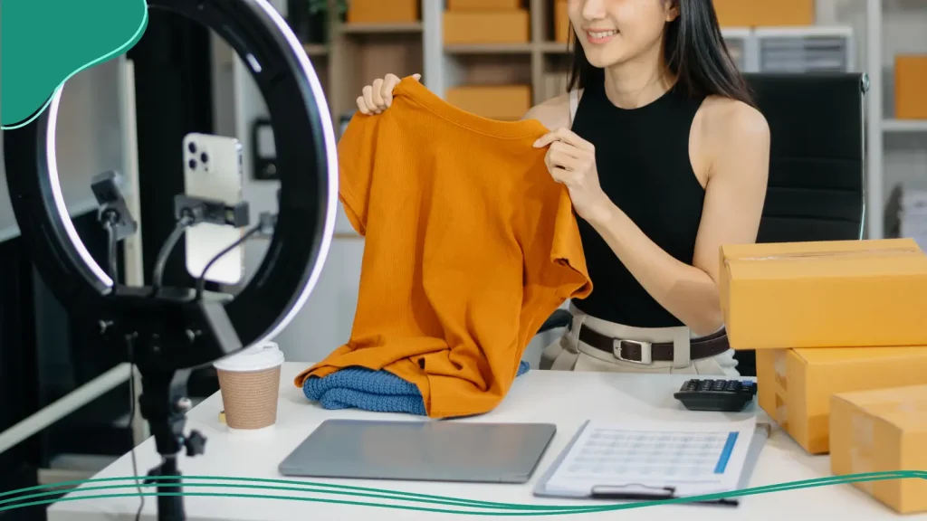 Woman holding up an orange shirt