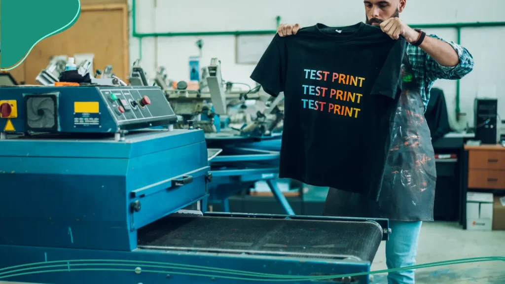 A man removing a test t-shirt from a printer