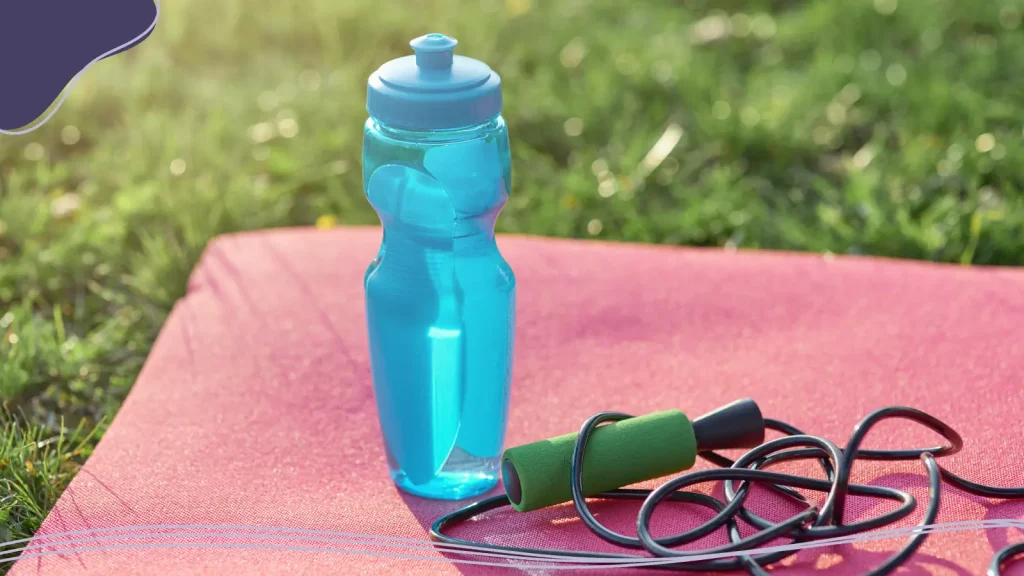 Plastic water bottle and a jump rope on a mat