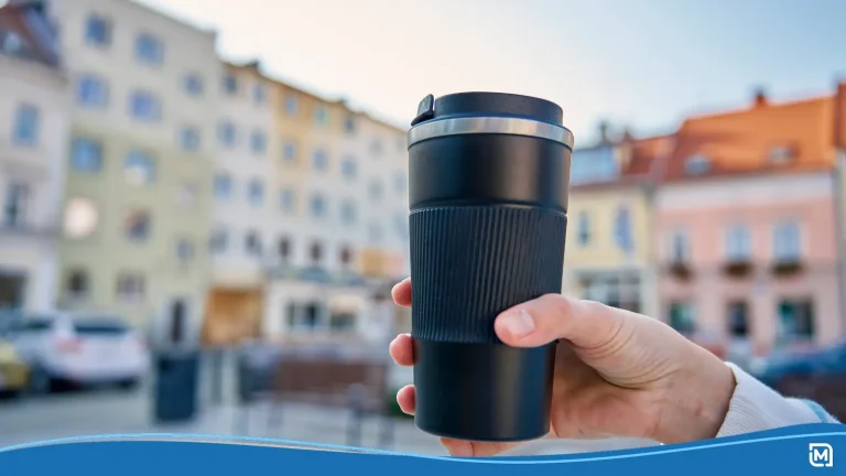 Person holding custom drinkware in a city