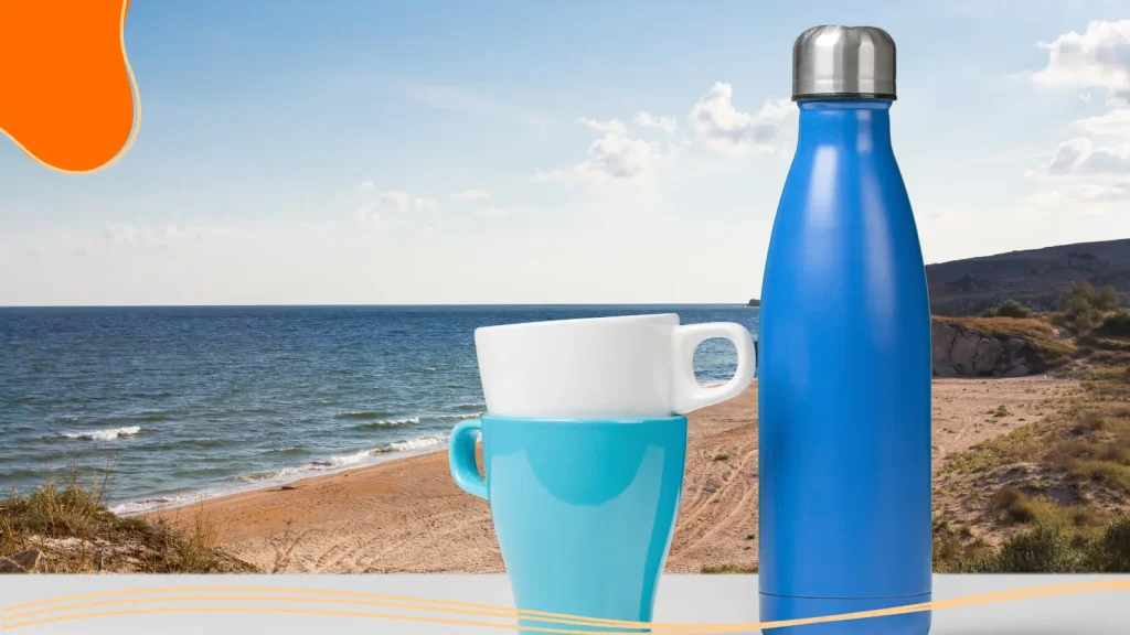 Mugs and a water bottle near a beach