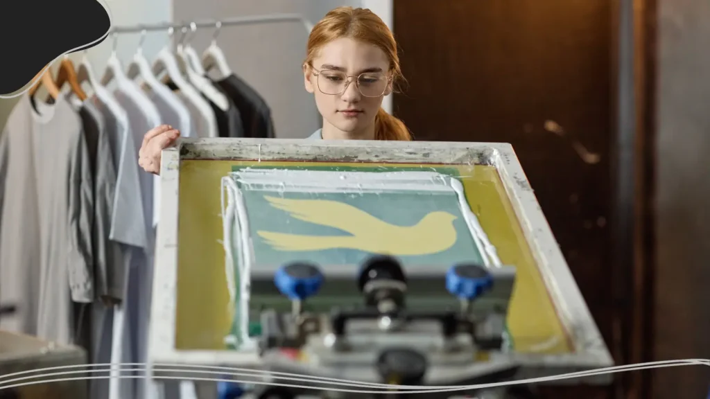 Woman holding up a screen printed T-shirt