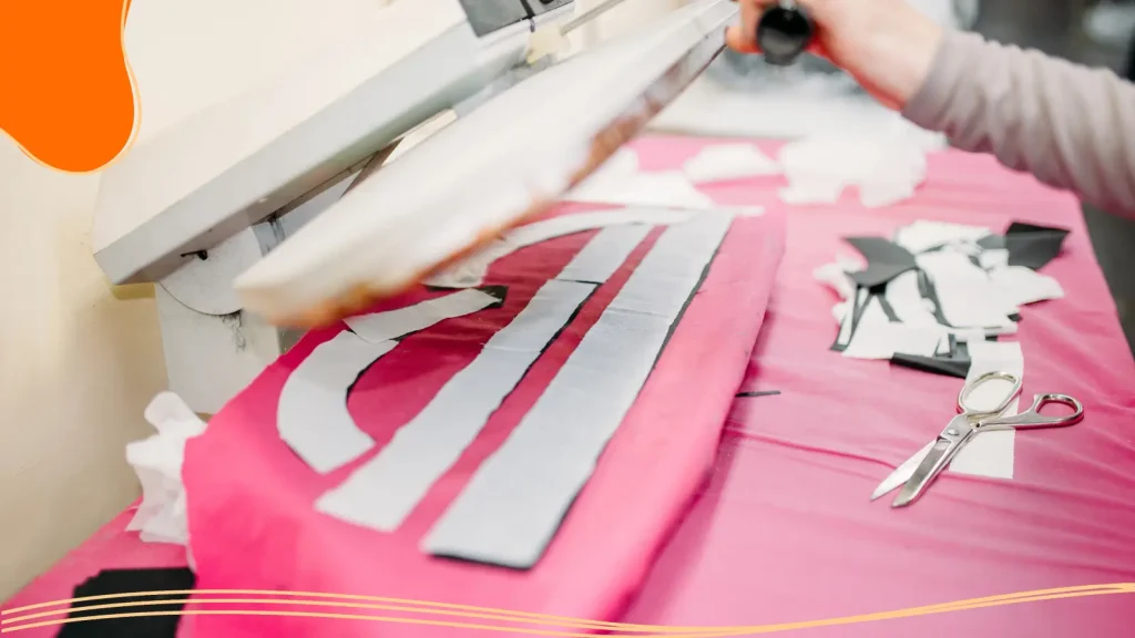 A person positioning a logo on a promotional T-shirt
