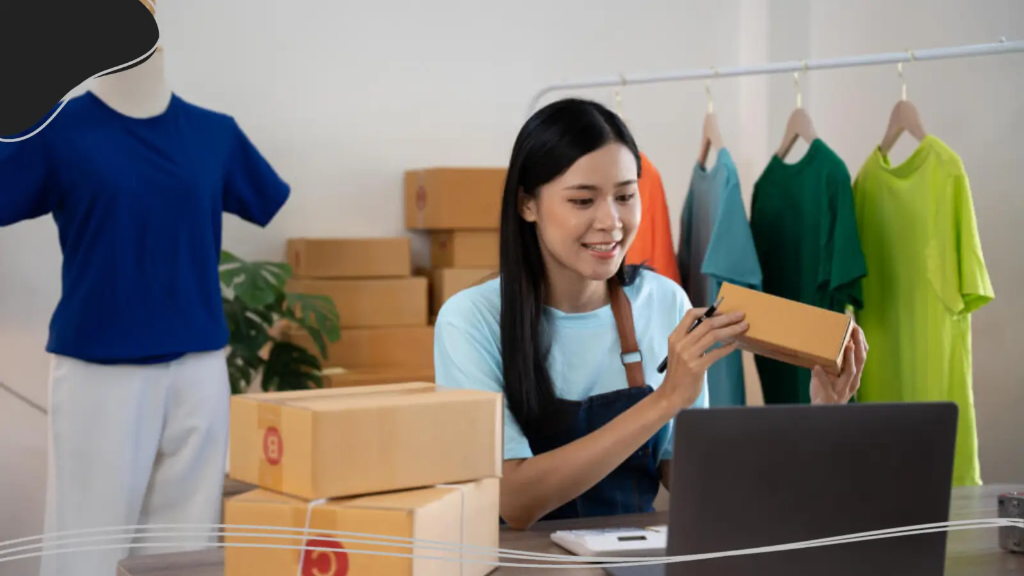 A young woman smiles at her laptop, pleased with sales after working to build her company up through personalized branding online.