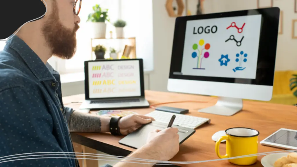 A young man designing a logo at his desk, brainstorming corporate gift ideas for a branding project.