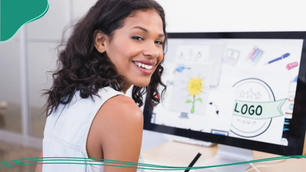 A young woman designs a custom logo on a desktop computer, creating branding for company swag ideas.