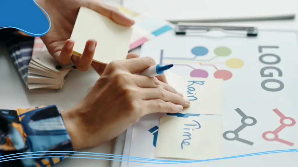 A close-up photograph of someone's hands creating a logo design on a board, crafting the branding for some of the best promotional items.