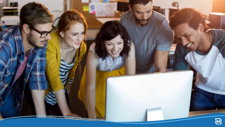 A team of young professionals gather around a computer to choose the best AI tool for logo design.