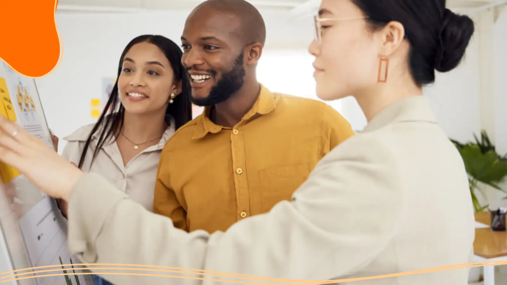 Three young professionals stand in front of a design board and prepare their design for where to make business cards.