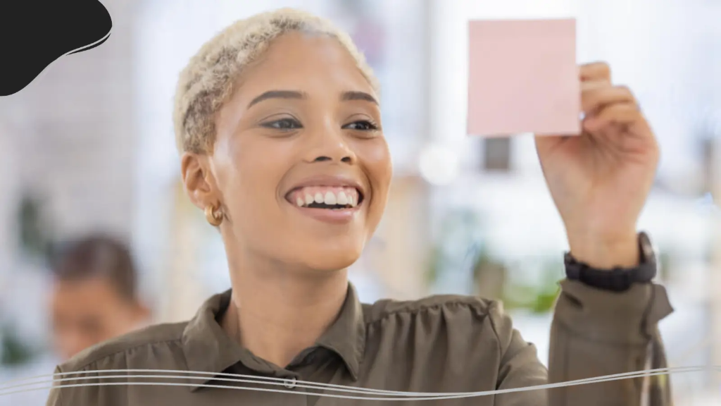 A young woman holds up a custom business card to approve it before ordering more printed business cards.
