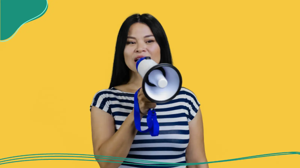 A young woman holds a loudspeaker to make her voice heard.