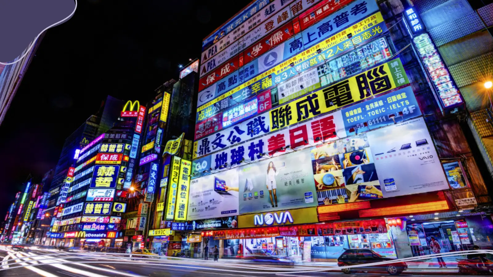 A vibrant city street at night lined with multi-story buildings covered in bright neon signs, advertisements, and Chinese characters, with light trails from moving traffic along the road, illustrating the energy of custom brands in a dynamic urban setting.