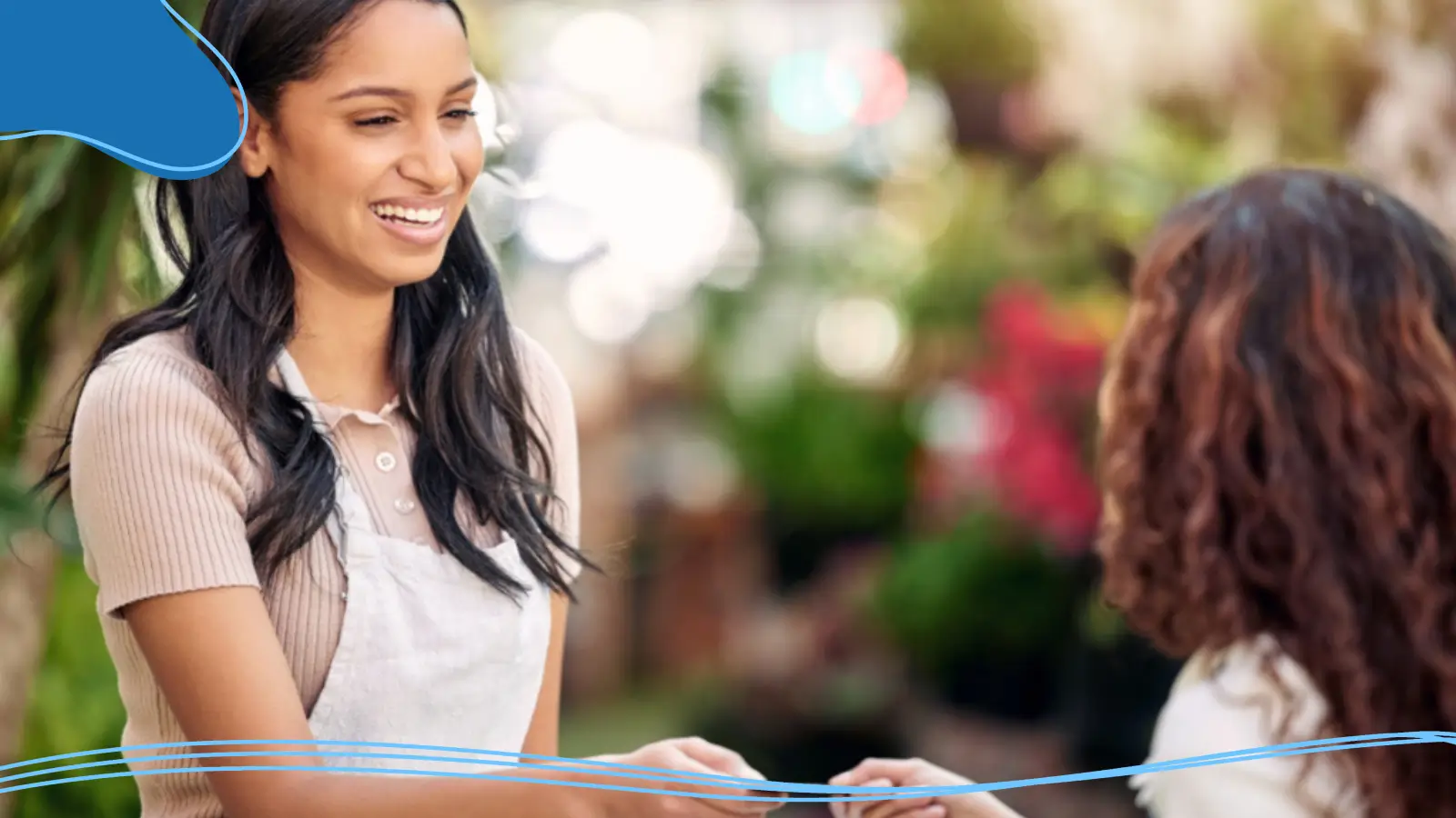 A smiling worker offers her business card to a customer, highlighting make your own brand through personal connection and professional identity.