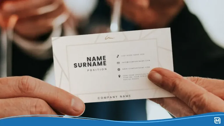 Close-up of two people exchanging a crisp white card at a networking event, highlighting how Are Business Cards Still Relevant in modern professional settings.