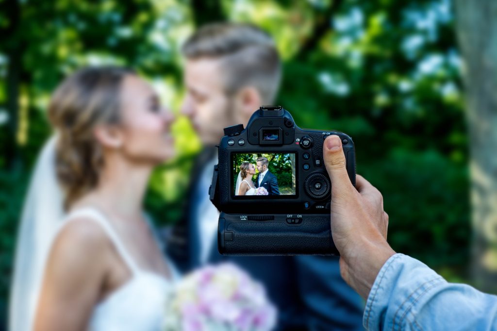 photographer taking picture of married couple